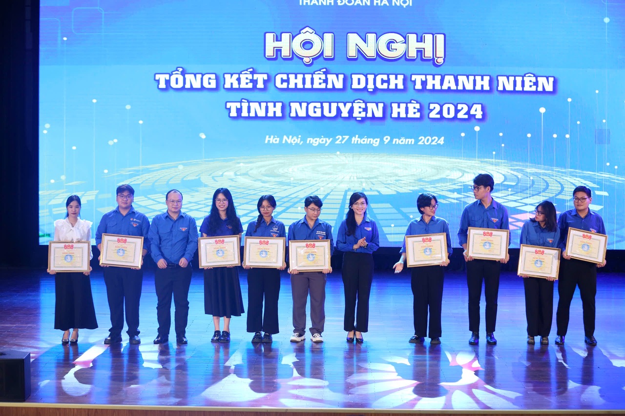 A group of people holding certificates Description automatically generated